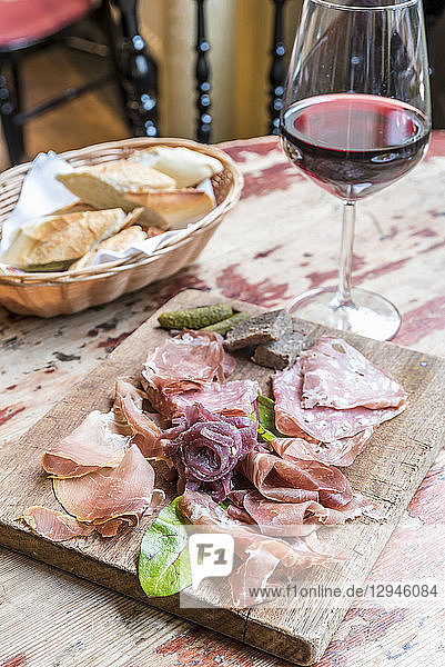 Board with cold meats and charcuteries  salami  prosciutto with bread in the background
