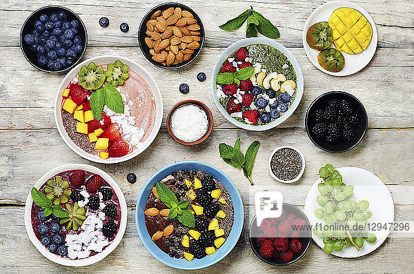 Variation von gesunden Smoothie-Frühstücks-Bowls mit Beeren  Früchten und Nüssen