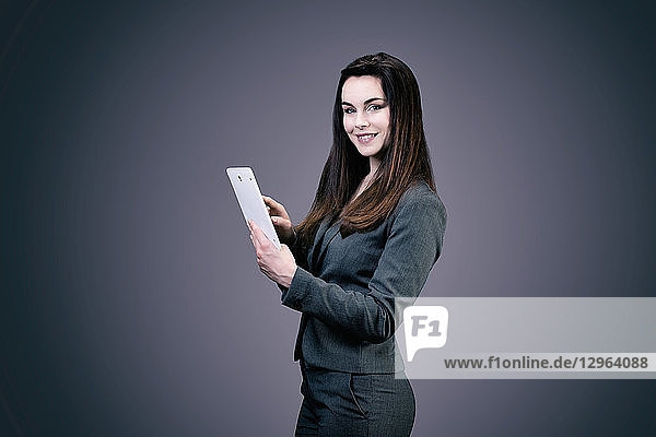 Porträt einer lächelnden jungen Geschäftsfrau  ein Touchpad in den Händen