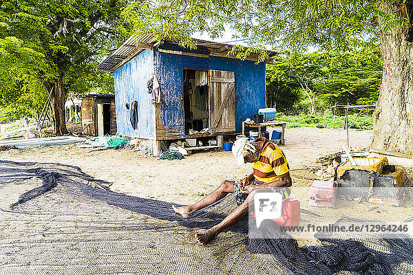 Alter Fischer  der sein Netz repariert  am Strand  vor seiner Hütte  Chatham Bay  Union  St-Vincent  St. Vincent und die Grenadinen  Kleine Antillen  Westindische Inseln  Inseln über dem Winde  Karibik  Mittelamerika