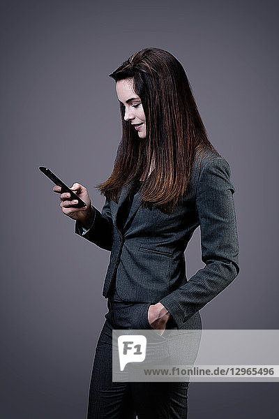 Portrait of a smiling young businesswoman writing a text message