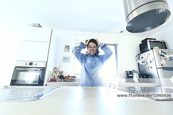 Brünette Frau in ihrer Küche am Morgen.