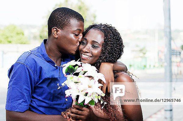 Ein junger Mann gibt seiner Freundin einen Kuss  der sich so anfühlt.
