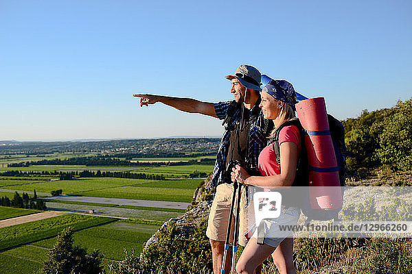 Ein junges Paar wandert auf einem Abenteuertrek und betrachtet die schöne Landschaft bei Sonnenuntergang.