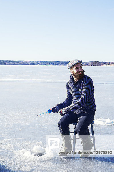 Man fishing on frozen lake in Dalarna  Sweden
