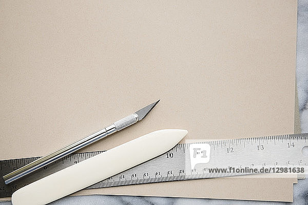 Messer  Papierschneider und Lineal auf Papier