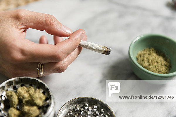 Die Hand einer Frau hält einen Marihuana-Joint