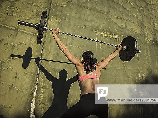 Woman weight lifting with barbell