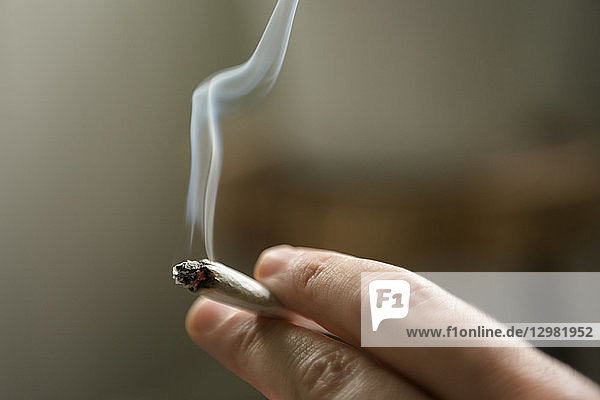 Hand einer Frau  die einen Marihuana-Joint raucht