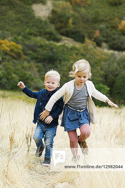 Boy and girl running in field
