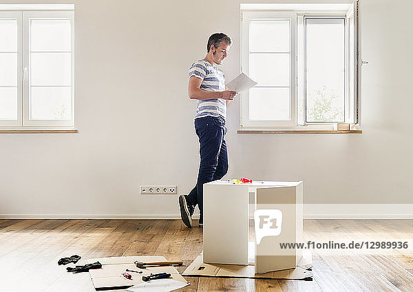DIY - Mann mit Bausatz eines Schränkchens