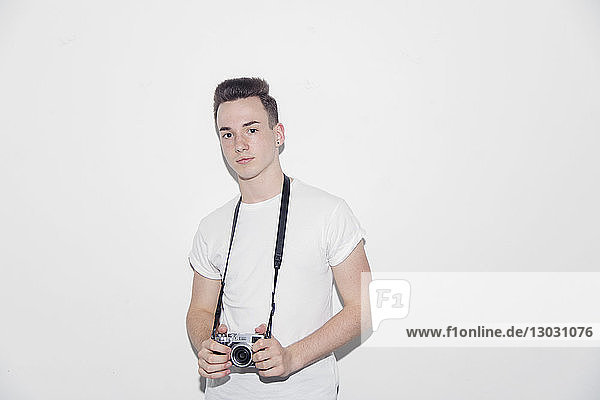 Portrait confident  cool teenage boy holding retro camera