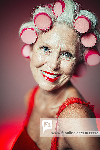Porträt lächelnde  selbstbewusste ältere Frau mit Lockenwicklern im Haar