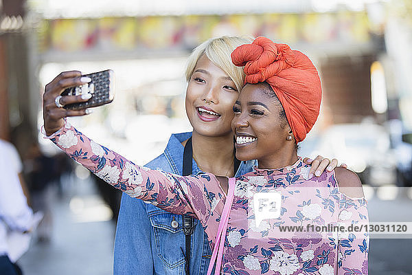Happy young women taking selfie with camera phone