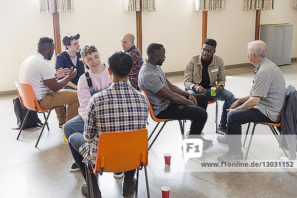 Men talking in group therapy in community center