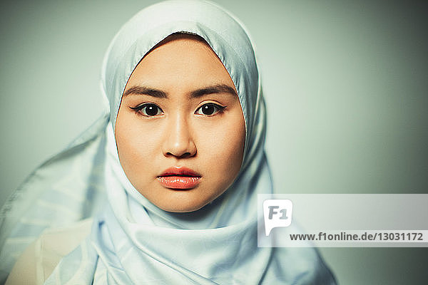 Porträt einer selbstbewussten  ernsten jungen Frau  die einen blauen Hidschab aus Seide trägt