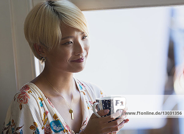 Smiling young woman drinking coffee