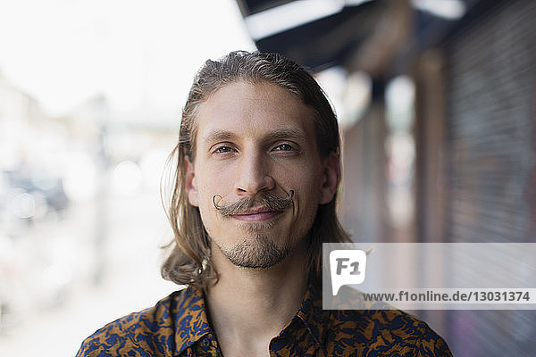 Porträt selbstbewusster junger männlicher Hipster mit Schnurrbart