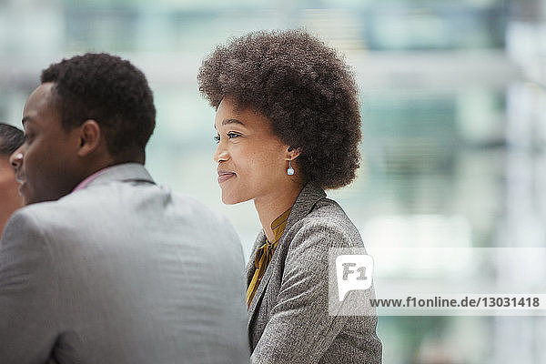 Smiling  confident businesswoman listening in meeting