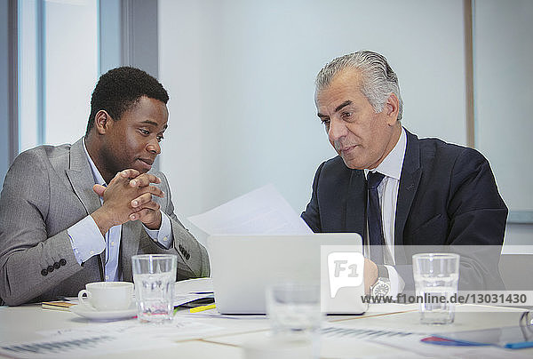 Businessmen discussing paperwork in meeting