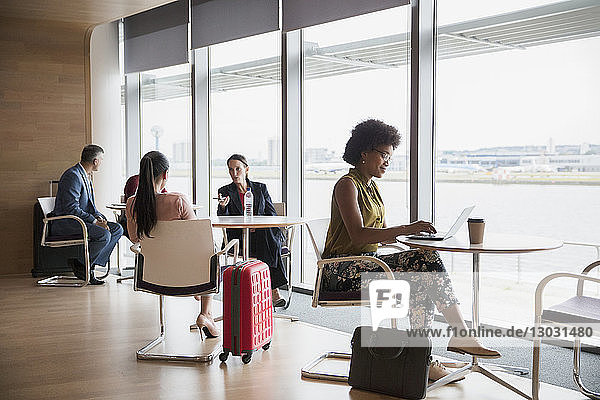 Geschäftsleute  die in der Business-Lounge eines Flughafens arbeiten