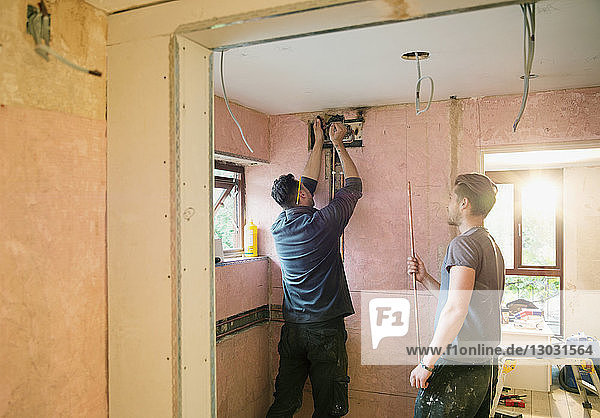 Bauarbeiter bei der Installation von Kupferrohren in einem Haus
