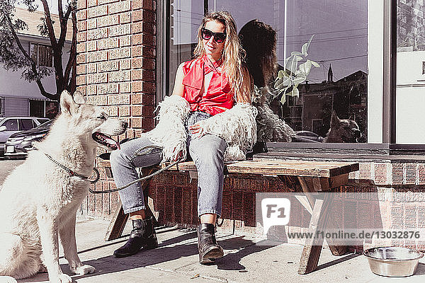 Junge Frau mit Haushund an der Ladenfront