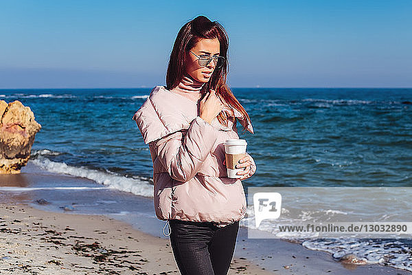 Stilvolle Frau mittleren Alters beim Strandspaziergang mit Kaffee zum Mitnehmen  Odessa  Odeska Oblast  Ukraine