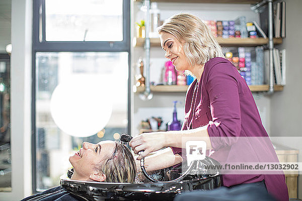 Friseur spült den Kunden im Salon die Haare