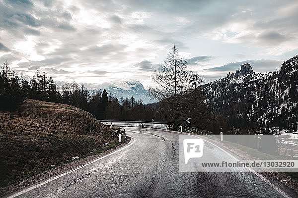 Rural road in snow capped mountains  Dolomites  Italy