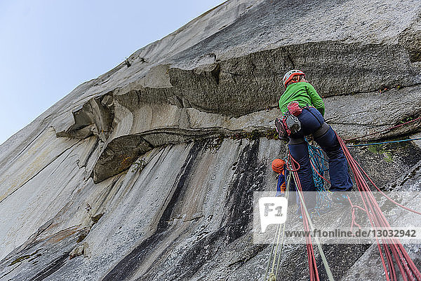 Junge Bergsteigerin beim Klettern an einer Felswand  Niedrigwinkelansicht  The Chief  Squamish  Britisch-Kolumbien  Kanada