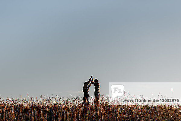 Romantischer Mann und Freundin im Feld aus langem Gras  Fernsicht