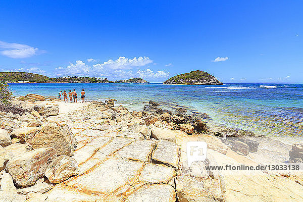 Menschen auf Felsen mit Blick auf das kristallklare Meer  Half Moon Bay  Antigua und Barbuda  Leeward Islands  Westindische Inseln  Karibik