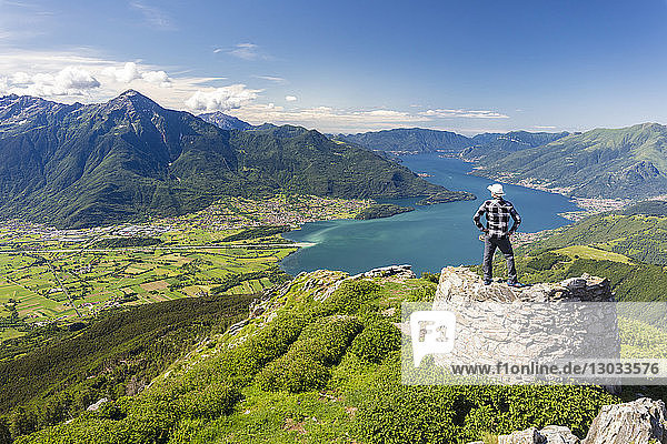 Hiker on top of Monte Berlinghera looks towards Colico and Monte Legnone  Sondrio province  Lombardy  Italy