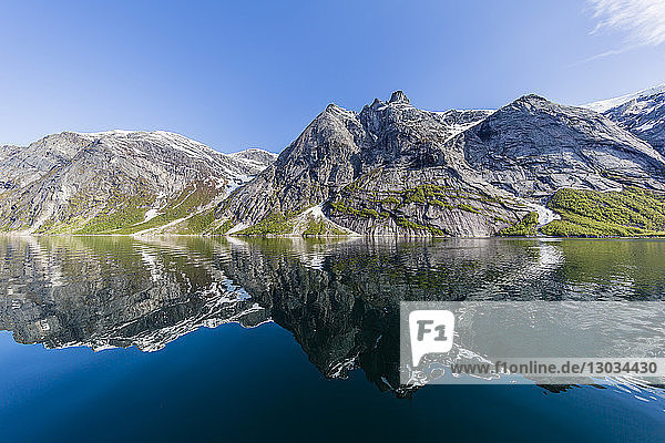 Schneebedeckte Berge spiegeln sich im ruhigen Wasser des Nordfjords  tief im Inneren des Melfjords  Norwegen  Skandinavien