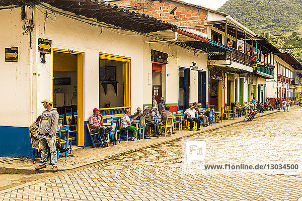Local people socialising on the main square  with its preserved  colourful  colonial buildings  Jardin  Colombia