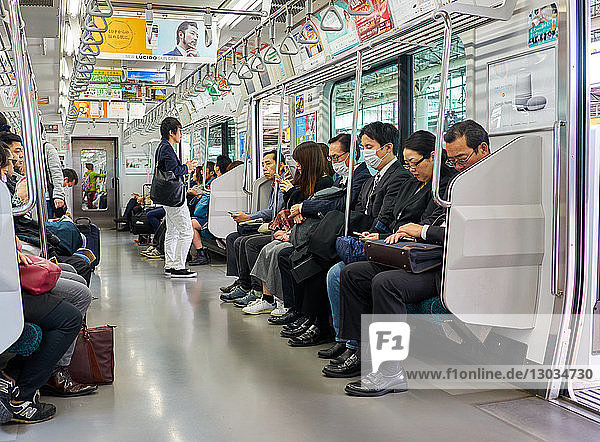 Passengers on a Tokyo subway train  Tokyo  Japan