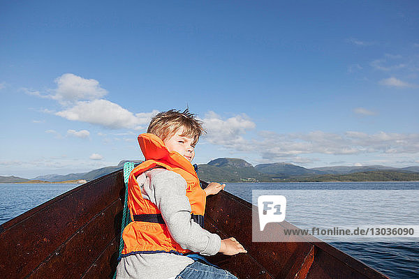 Junge  der von vorne vom Ruderboot aus zurückblickt  Aure  More og Romsdal  Norwegen