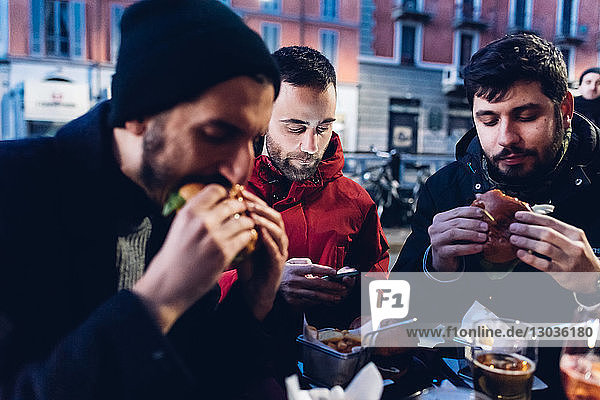 Freunde genießen Burger im Freiluftcafé  Mailand  Italien