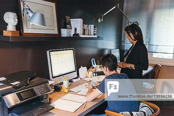 Woman and son working in home office