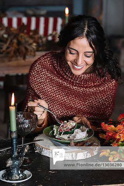 Junge Frau isst frischen Salat am Oldtimer-Tisch