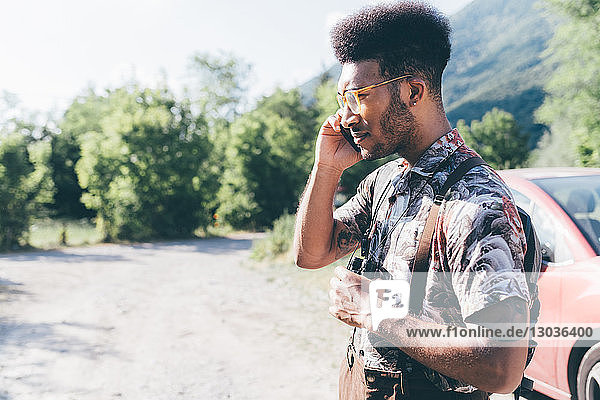 Young male hiker on rural dirt track making smartphone call  Primaluna  Trentino-Alto Adige  Italy