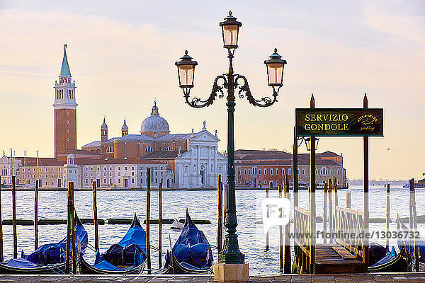 Gondeln auf dem Markusplatz am Wasser mit der Kirche San Giorgio Maggiore im Hintergrund  Venedig  Venetien  Italien