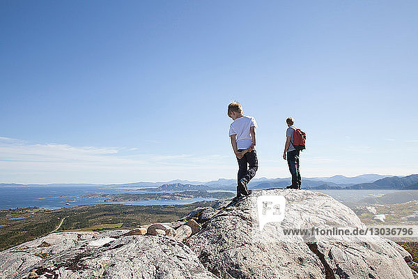 Boy and father looking out from rock formation over landscape  Aure  More og Romsdal  Norway