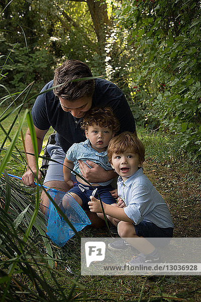 Vater und Kinder mit Fischernetz im Park