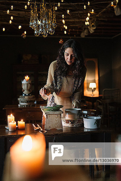 Young woman at vintage table serving risotto