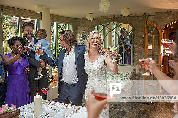 Wedding guests toasting to newlyweds at reception