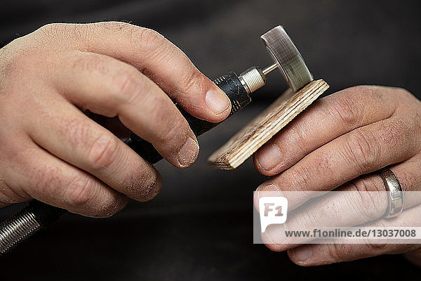 Carpenter sanding wood square with sanding tool
