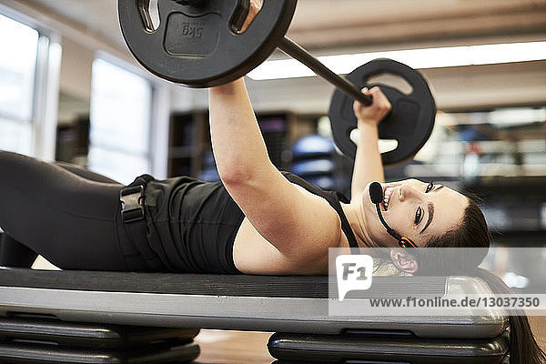 Seitenansicht einer einzelnen weiblichen Fitness-Trainerin beim Bankdrücken