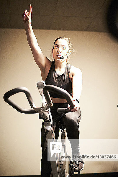 A spinning instructor riding the bike in the spin studio at the gym